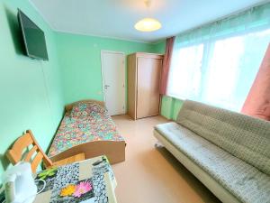 a small room with a bed and a couch at Neringos 8 in Palanga