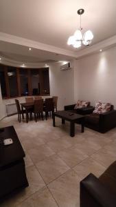 a living room with couches and a table and chairs at Elite Apartments in Yerevan