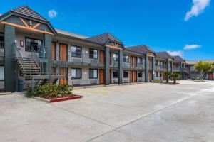 a row of apartment buildings with a parking lot at Hotel Hacienda at Ontario Ranch in Ontario