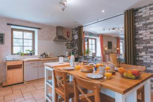 una cucina con tavolo in legno e arance di Une parenthèse en Ardenne a Nollevaux