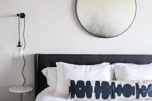 a bedroom with a mirror above a bed with white pillows at Bowline Hotel in Astoria, Oregon