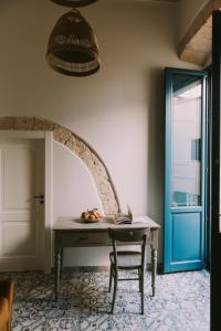 una mesa y una silla en una habitación con puerta azul en Zia Marietta Guest House, en Altamura