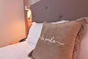Postel nebo postele na pokoji v ubytování Hotel La Perla