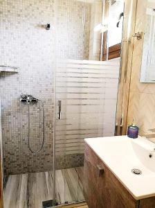uma casa de banho com um chuveiro e um lavatório. em Avra Studios em Kími