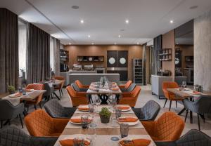 ein Restaurant mit Tischen und Stühlen und einer Küche in der Unterkunft Hotel Raymond in Truskawez
