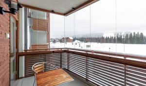 a balcony with a bench and a large window at Tahko Chalets B402 in Tahkovuori