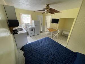 a bedroom with a blue bed and a kitchen at Coconut Cove Resort & Marina in Islamorada
