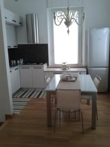 a kitchen with a table and a white refrigerator at Appartamento in Villa in Pesaro