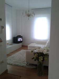 una sala de estar con un jarrón de flores y un sofá en Appartamento in Villa, en Pesaro