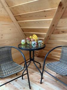 einen Tisch mit einer Obstschale und 2 Stühlen in der Unterkunft Hillside Bio Glamping in Prebold