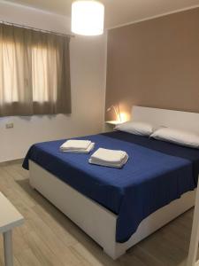 Casa Giulia في Niscemi: غرفة نوم عليها سرير وفوط