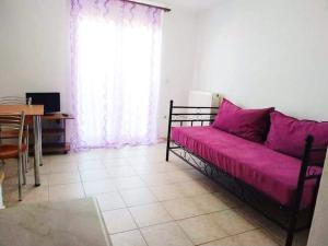 a living room with a couch with a pink blanket at Avra Studios in Kymi