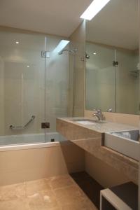 a bathroom with a sink and a mirror and a tub at Hotel Anjo de Portugal in Fátima +38 photos