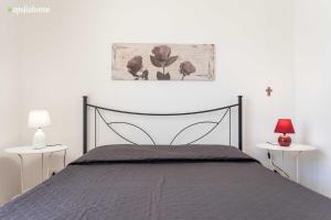 マリーナ・ディ・マンカヴェルサにあるAppartamento Violettaのベッドルーム1室(ベッド1台、ランプ付きテーブル2台付)