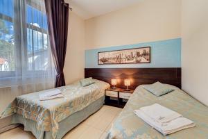 a hotel room with two beds and a window at Villa Porto in Pobierowo