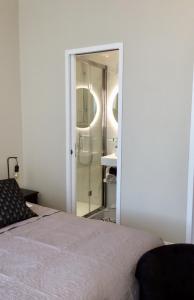 a bedroom with a bed and a bathroom with a shower at Les Sous Bois in Saint-Laurent-de-Brévedent