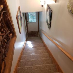una escalera que conduce a una habitación con puerta en Lolly's Treehouse, en Highlands