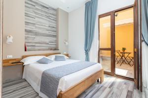 a bedroom with a large bed and a balcony at Vittoria Rooms in Quartu SantʼElena
