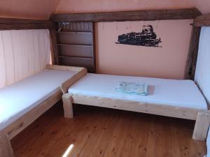 2 camas en una habitación pequeña con un tren en la pared en West Bohemian Home, Krajkova 208, en Krajková
