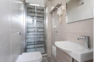a bathroom with a shower and a toilet and a sink at Vittoria Rooms in Quartu SantʼElena