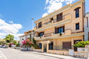 an apartment building with balconies on a street at Vittoria Rooms in Quartu SantʼElena