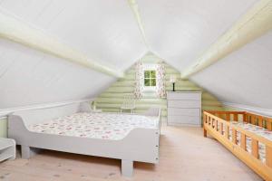 een slaapkamer met een wit bed op zolder bij Lillekleiv in Høvåg