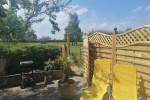 トローブリッジにあるCrown Cabin Wiltshire near Longleat and Bathのプライバシーフェンス(椅子2脚、グリル付) +14枚の写真