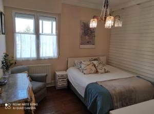 1 dormitorio con 1 cama, 1 silla y ventanas en Acogedor piso de 3 habitaciones cerca del metro, en Getxo