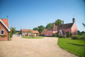 un groupe de maisons avec allée en gravier dans l'établissement Colston Hall Cottages, à Framlingham