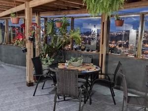 una mesa y sillas en un balcón con plantas en Suites Bella vista, en Campos do Jordão