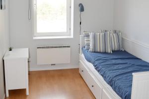 a white bedroom with a bed and a window at Solhem Bohus Björkö in Björkö