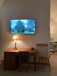 escritorio con 2 sillas y TV en la pared en Lolly's Treehouse, en Highlands