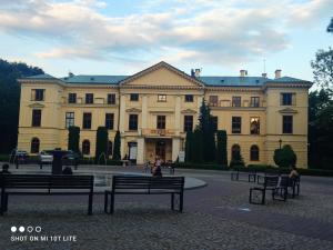 a large building with benches in front of it at Perła Apartament Mińsk in Mińsk Mazowiecki