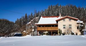 uma casa com neve em cima em Apartament u Bronka em Duszniki Zdrój