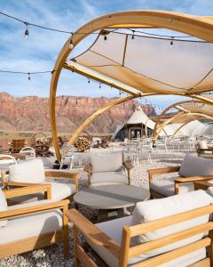 un groupe de chaises et de tables avec des montagnes en arrière-plan dans l'établissement Under Canvas Zion, à Virgin