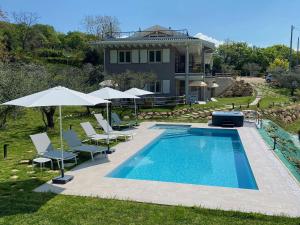 basen z leżakami i parasolami obok domu w obiekcie Villa Nina - Apartments & Relax w mieście Caprino Veronese