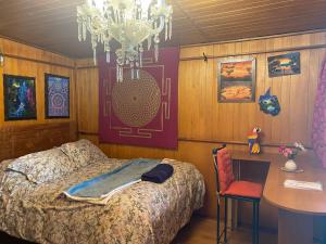 a bedroom with a bed and a table and a chandelier at Casa de la Gringa Mountain House in Cusco