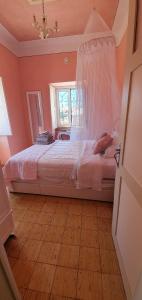 um quarto com uma cama branca e uma janela em Villa Rosa Boutique em Almancil