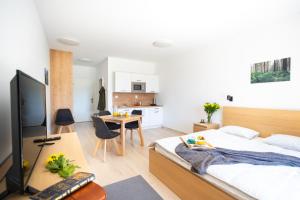 a bedroom with a bed and a table and a kitchen at Apartmán Vila Zuberec in Zuberec