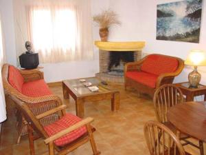 a living room with chairs and a fireplace at Cortijo La Luna in Almuñécar