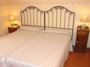 a bedroom with a white bed with two night stands at Cortijo La Luna in Almuñécar