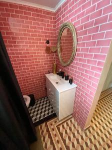 a pink bathroom with a sink and a mirror at Villa Rosa Boutique in Almancil