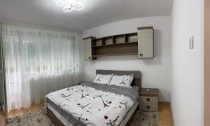 una camera con un letto e una parete bianca di Apartament Denisa a Orşova
