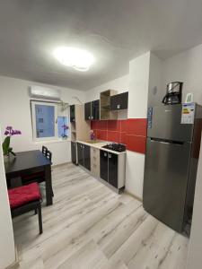 una cucina con frigorifero e tavolo di Apartament Denisa a Orşova