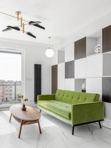 a living room with a green couch and a table at CITYSTAY Dluga Grobla Gdansk Apartment with Sauna in Gdańsk