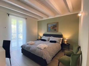 sypialnia z łóżkiem i krzesłem w obiekcie Villa Nina - Apartments & Relax w mieście Caprino Veronese +37 zdjęć