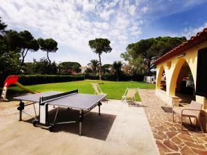 un tavolo da ping pong in un cortile con sedie di villa Letizia a Pula