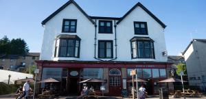 a large white building with people sitting outside of it at Aberfoyle Inn in Aberfoyle