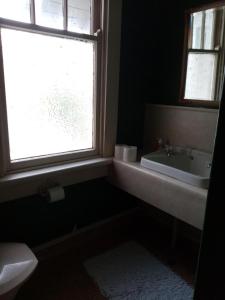 een badkamer met een wastafel en een raam bij Manakau House The Old Manakau Hotel 1920 in Manakau