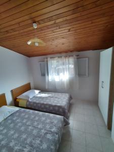 - une chambre avec deux lits et un plafond en bois dans l'établissement Holiday house "Uvala Jaz - Telašćica", à Sali